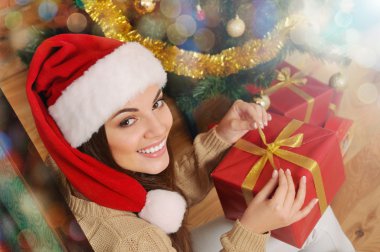 gülümseyen genç kadın ile santa şapka Noel t mevcut kutusunda