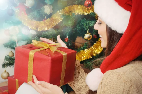 Hermosa mujer joven con caja de regalo en sombrero de santa en Navidad — Foto de Stock