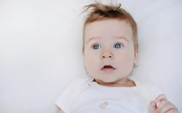 Portrait of cute little baby boy lying on soft white pillow — Stock Photo, Image