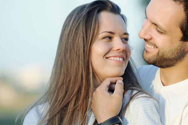 портрет чувственной счастливой молодой влюбленной пары, позирующей летом
