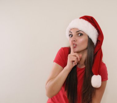 funny young woman in Santa hat having a secret from you for Chri clipart