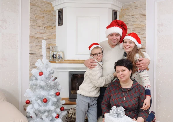 Szczęśliwą rodzinę w Santa hat zabawy kominku w Boże Narodzenie — Zdjęcie stockowe