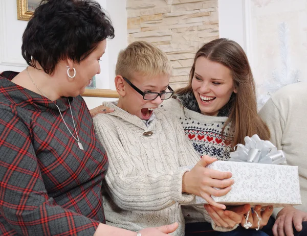 Szczęśliwy, uśmiechnięty chłopiec korzystających prezent na Boże Narodzenie z rodziną — Zdjęcie stockowe