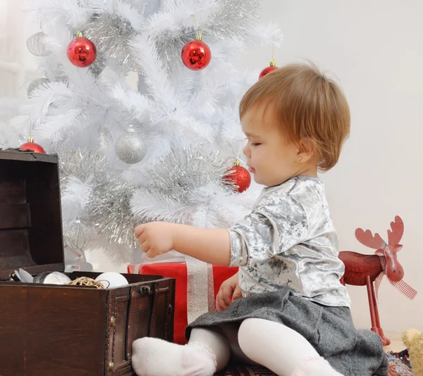 Mała dziewczynka bawi się zabawkami świątecznymi — Zdjęcie stockowe