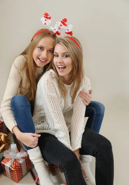 Two funny girls on the sled with gifts — Stock Photo, Image