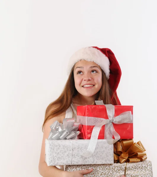 Sorridente bella ragazza a Babbo Natale cappello con regali sognando ab — Foto Stock