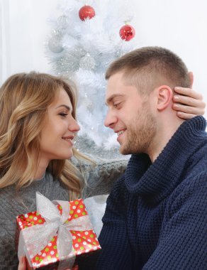 güzel çift kucaklama bir Noel ağacı arka planda