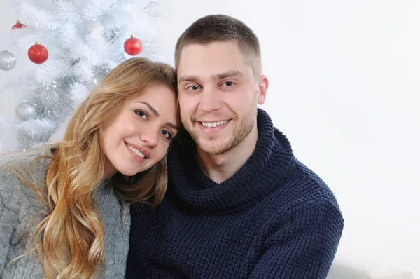 Happy smiling couple at the Christmas tree — Stock Photo, Image