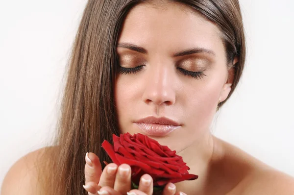 Portrait rapproché d'une belle femme sentant la rose rouge — Photo