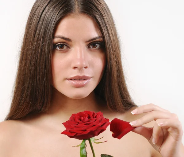 Cute beautiful woman tears off petals of red rose and looking at — Stock Photo, Image