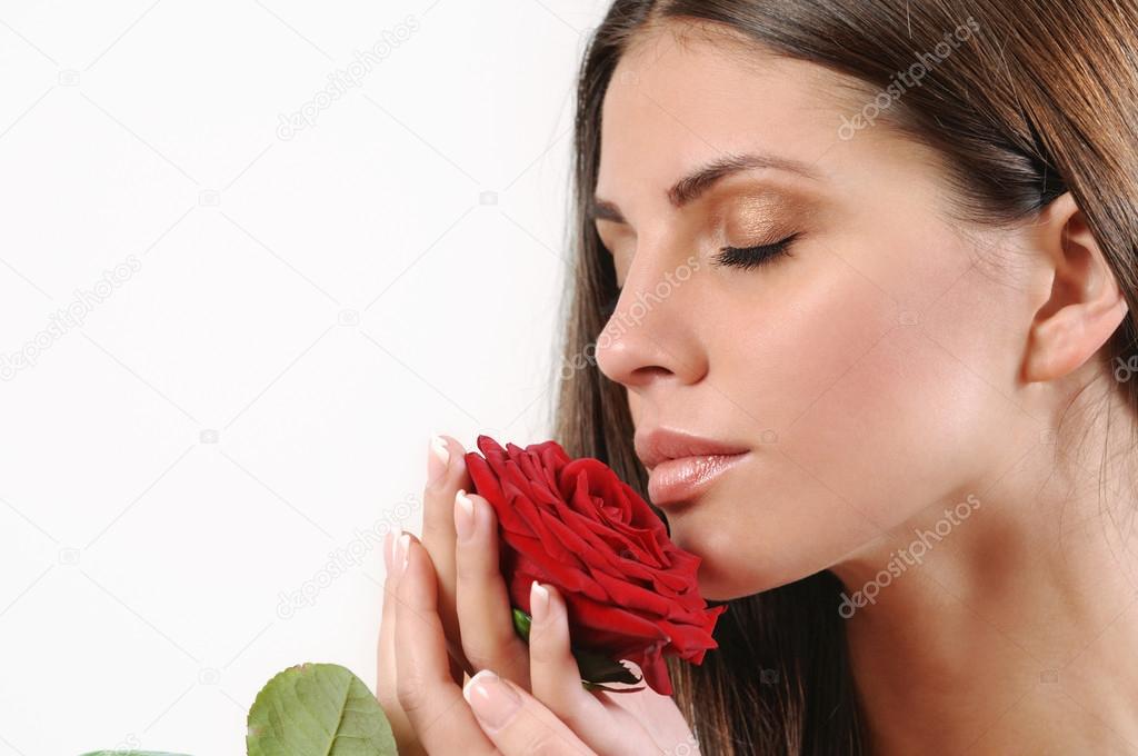 Cute beautiful woman smell red rose on white background