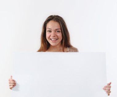 beautiful young woman holding a placard and smiling against a wh