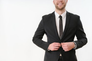 smiling business man body side button up his black suit on white