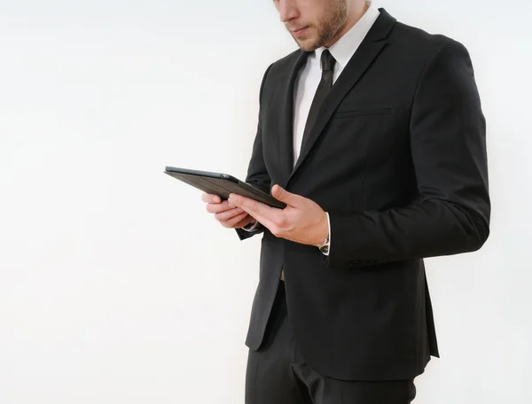 Homem de negócios lado do corpo em terno preto segurando seu tablet em branco — Fotografia de Stock