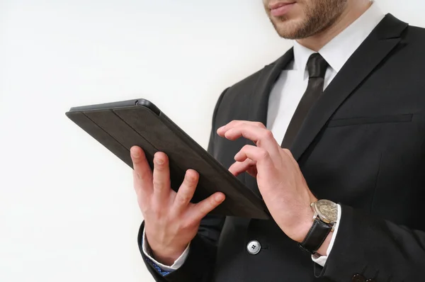 Homem de negócios lado do corpo em terno preto segurando seu tablet em branco — Fotografia de Stock