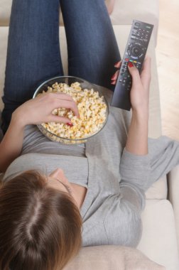 genç kadın evde rahatlatıcı bir hafta sonu harcama tv izlerken