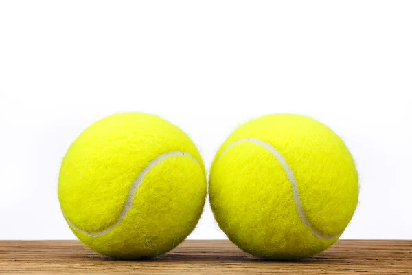 İki tenis topları izole ahşap masa