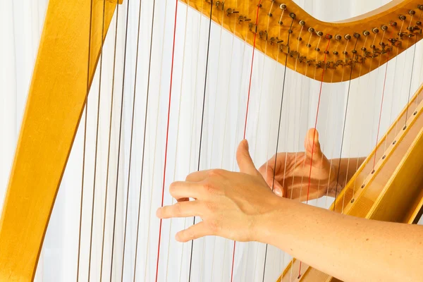 Fechar as mãos tocando harpa celta — Fotografia de Stock