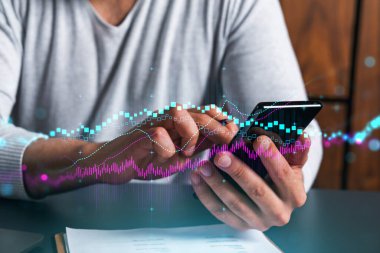 Telefonu kullanan adam. Akıllı telefon yazan eller. Ön x grafik hologramıyla çift pozlama. Kapatın. Finansal tablo ve analiz konsepti. Çevrimiçi ticaret ve yatırım.