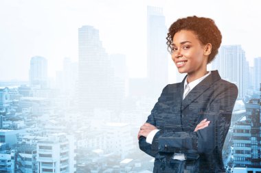 Kollarını kavuşturup gülümseyen siyahi Afro-Amerikalı iş kadını. Bangkok şehir manzarası. Kadın ticareti kavramı. Yatırım fonu. Çift pozlama.