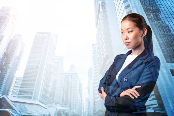 Процветающая азиатская бизнесвумен в костюме со скрещенными руками. Сингапурский городской пейзаж. Концепция женщины в бизнесе. Финансовый центр. Двойное воздействие. — стоковое фото