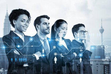 İş amaçlarına ulaşmak için sosyal medya pazarlama stratejisi üzerinde çalışan bir grup SMM uzmanı. Kuala Lumpur arkaplanı üzerinde hologram simgeleri.