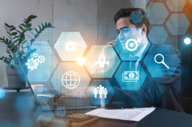 Ofisteki işadamı dizüstü bilgisayarla çalışıyor, işe fintech yaklaşımını geliştiriyor, yeni fırsatlar için veri topluyor. Çift pozlama.
