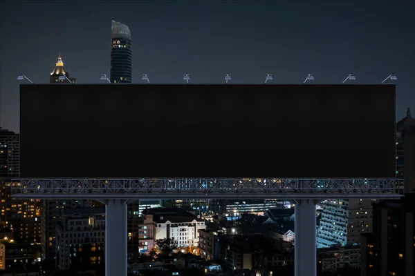 夜のバンコクの街並みを背景にした空白の黒い道路看板。ストリート広告ポスター、モックアップ、 3Dレンダリング。正面図。アイデアを販売するためのマーケティングコミュニケーションの概念. — ストック写真