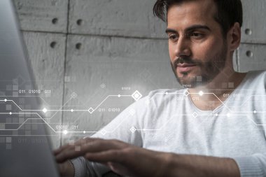 Sıradan giyinen ciddi bir beyaz adam yeni bir uygulama geliştirmek için dizüstü bilgisayar kullanıyor. Çifte maruziyet. Bilgi bağlantıları hologramı.