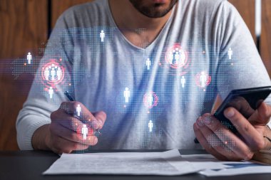 Bir adamın telefon ve dünya haritası hologramıyla kontrat imzalarken iki kez görüntülenmesi. Uluslararası iş kavramı.