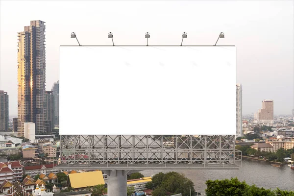 バンコクの街並みを背景にした空白の白い道路看板。ストリート広告ポスター、モックアップ、 3Dレンダリング。正面図。アイデアを宣伝または販売するためのマーケティングコミュニケーションの概念. — ストック写真