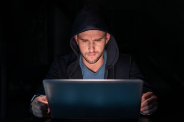 Karanlık odada dizüstü bilgisayarı olan siyah kapüşonlu bir bilgisayar korsanı, gece geç saatlere kadar çalışan kapüşonlu bir adam. Adam geceleri bir bilgisayar bilgisayarını hackliyor. Hacker kavramı