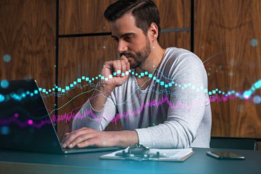 Ciddi bir Kafkasyalı analist gündelik giysiler içinde, dizüstü bilgisayar kullanarak borsa davranışlarını tahmin ediyor. Çifte maruziyet. Eski Hologram. İnternet ticareti kavramı.