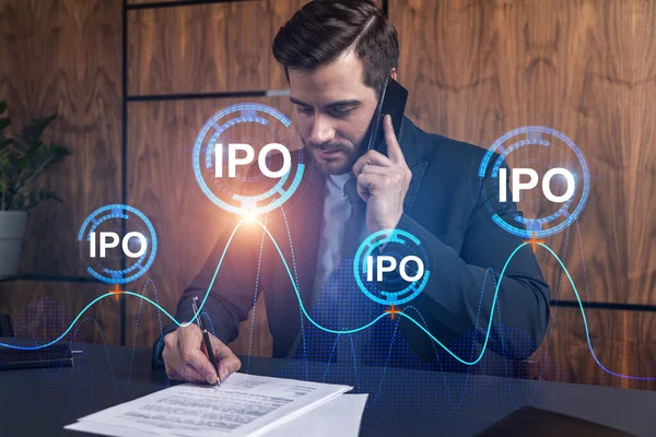 Un uomo in ufficio che firma documenti mentre parla di cellulare e ologramma dell'IPO. Doppia esposizione. Abbigliamento formale. Investimenti. — Foto Stock