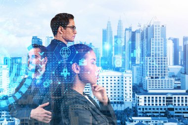 Bir grup iş arkadaşı araştırma ve geliştirme departmanındaki problemleri çözmek için yeni teknik yaklaşımlar bulmaya çalışıyor. Kuala Lumpur arkaplanı üzerinde Fintech hologram simgeleri.