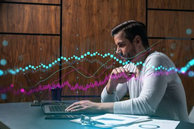 Ciddi bir Kafkasyalı analist gündelik giysiler içinde, dizüstü bilgisayar kullanarak borsa davranışlarını tahmin ediyor. Çifte maruziyet. Eski Hologram. İnternet ticareti kavramı.