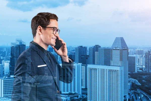 Prospero empresario guapo en traje y gafas pensativamente hablando teléfono y mirando en Singapur paisaje urbano. El concepto de consulta para la resolución de problemas. Vistas al centro. Doble exposición. — Foto de Stock