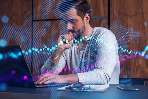 A serious caucasian analyst in casual wears, using laptop to proceed the forecast of stock market behavior. Double exposure. Forex Hologram. Concept of internet trading.