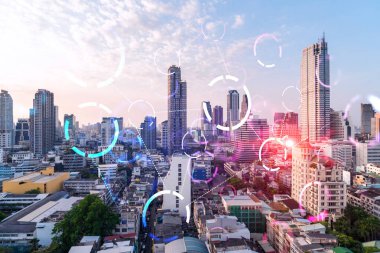 Soyut teknolojinin parlayan simgelerinin hologramı, günbatımında Bangkok 'un panoramik şehir manzarası, Asya. Dünyalar konsepti teknolojik değişiklikler. Çift pozlama.