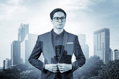 Takım elbiseli ve gözlüklü genç yakışıklı işadamı MBA mezuniyetinden sonra yeni kariyer fırsatları hayal ediyor. Bangkok arka planda. Çift pozlama.