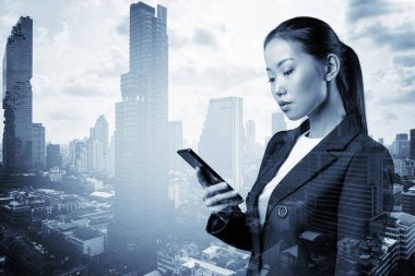 Takım elbiseli başarılı Asyalı iş kadını şirket toplantısının detaylarını mesaj atıyor. Bangkok şehir manzarası. İş iletişimi kavramı. Çift pozlama.