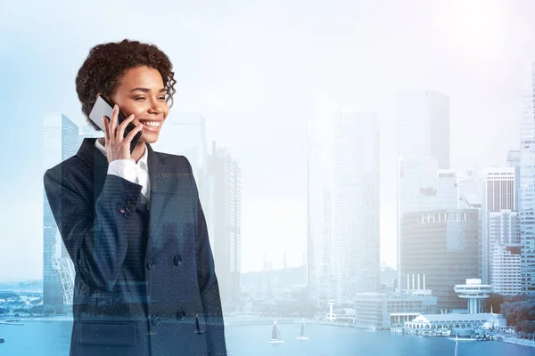 Успішно посміхаючись чорній афроамериканській бізнес-жінці в костюмі енергійної розмови по телефону, Сінгапурській цитаделі. Концепція консультантів як розв'язувачів проблем. Інвестиційний фонд. Подвійний вплив. — стокове фото
