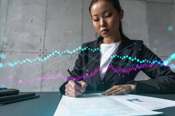 A woman signs contract and forex chart hologram. Concept of stock market analysis. Multiexposure. International business.