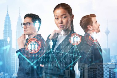İş amaçlarına ulaşmak için sosyal medya pazarlama stratejisi üzerinde çalışan bir grup SMM uzmanı. Kuala Lumpur arkaplanı üzerinde hologram simgeleri.