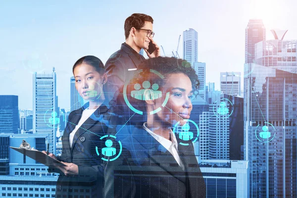 İş amaçlarına ulaşmak için sosyal medya pazarlama stratejisi üzerinde çalışan bir grup SMM uzmanı. Singapur arkaplanı üzerinde hologram simgeleri.