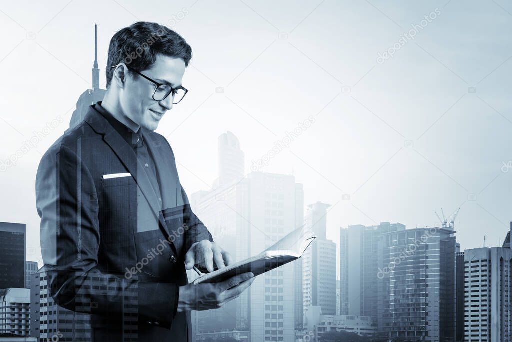 Young handsome businessman in suit and glasses thinking how to tackle the problem, new career opportunities, MBA assignment. Kuala Lumpur on background. Double exposure.