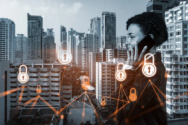 Attractive black businesswoman developer having conference call to protect clients confidential information by inventing solutions. IT lock icons over Bangkok city background.