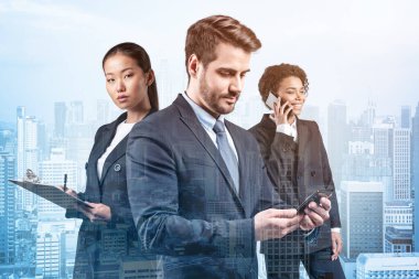 Takım elbiseli üç iş arkadaşından oluşan bir grup yeni kariyer fırsatları elde etmek için proje üzerinde birlikte çalışıyorlar. Çok uluslu şirket takımı kavramı. Kuala Lumpur. Çift pozlama.