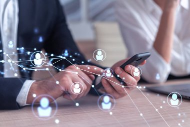 Resmi olarak pazarda çalışan iki insan kaynakları uzmanı uluslararası danışmanlık şirketinde yeni stajyerler bulmak için telefon kullanıyor. Sosyal ağ ve ortam hologramı simgeleri.