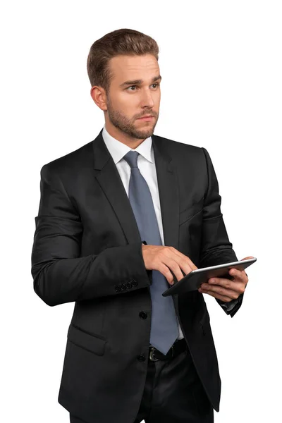 Uomo d'affari in completo nero e cravatta con tablet isolato su sfondo bianco — Foto Stock